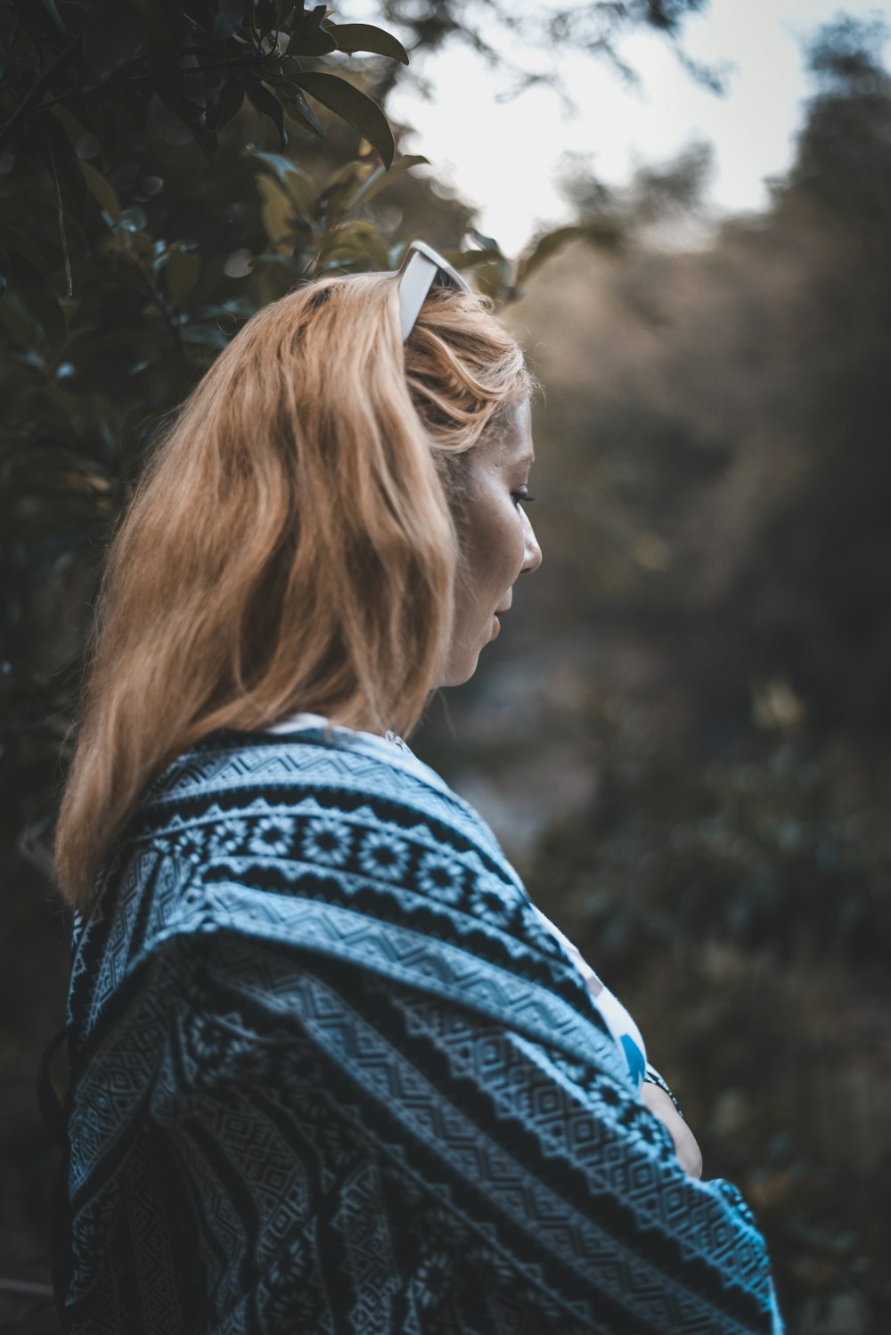 standing woman in blue and black aztec jacket