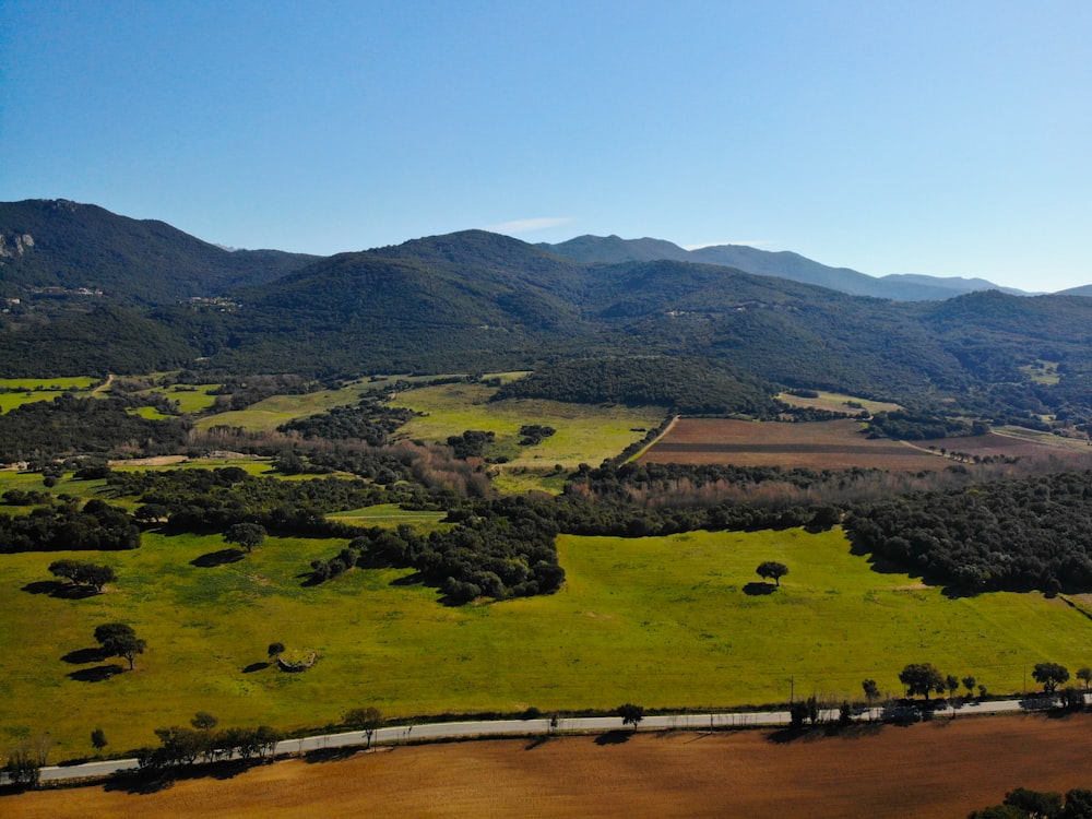 wide-angle photography of open field and mountain range during daytime