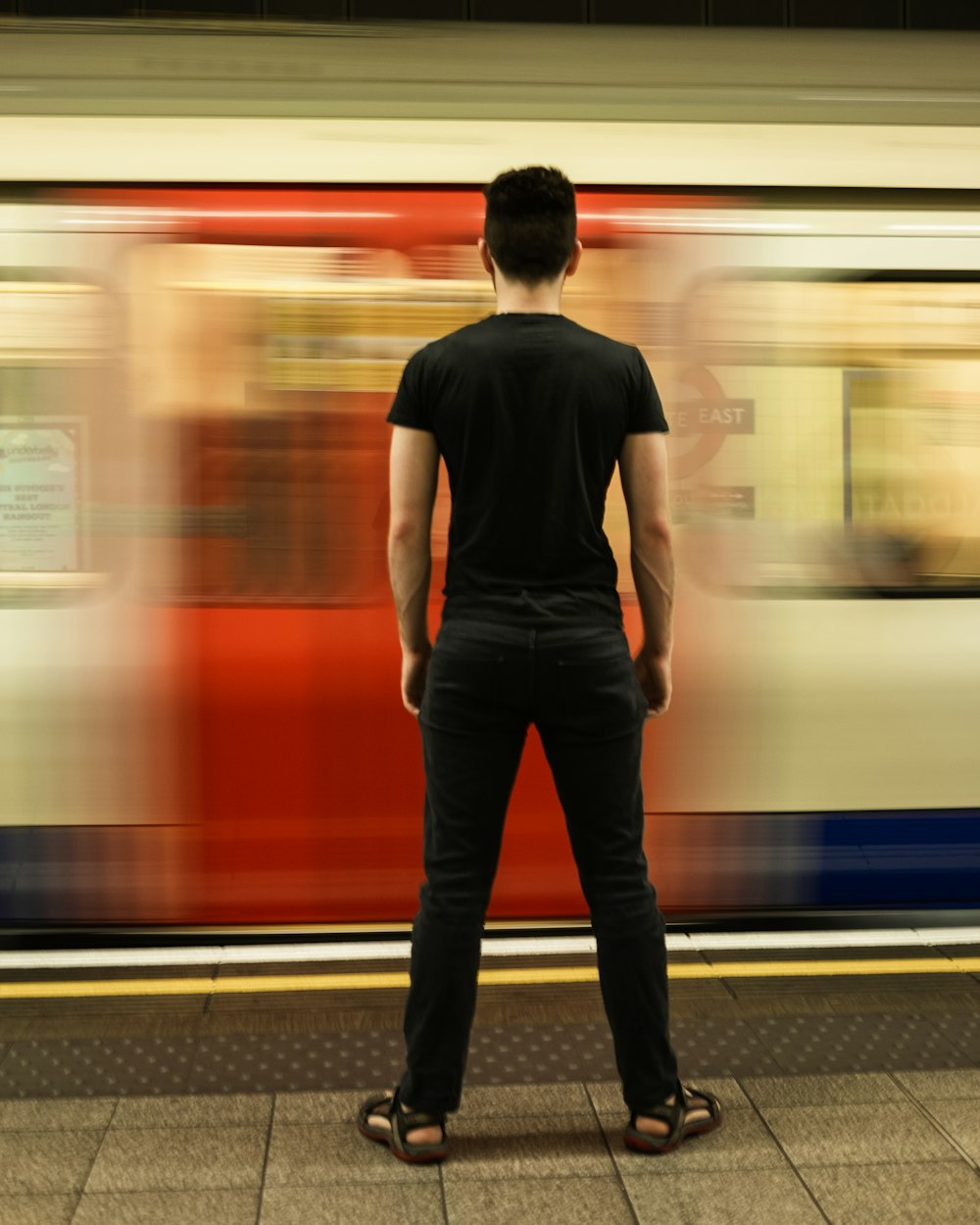 man in black t-shirt standing near train