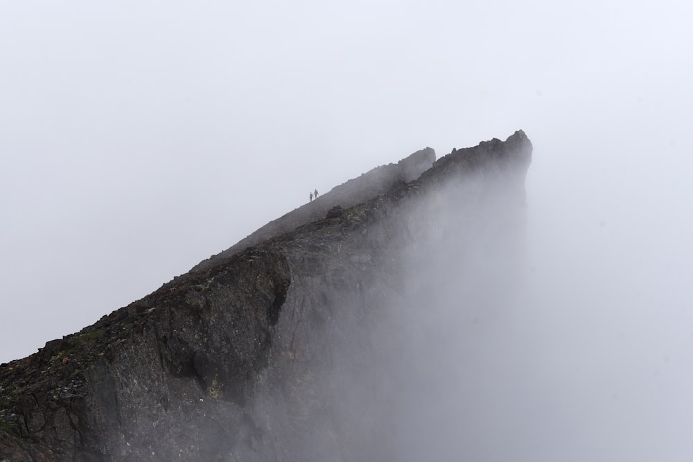 Zwei Menschen auf dem Gipfel des Berges mit Nebel