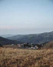 A peaceful scene of a small village receiving aid supplies under a clear blue sky.