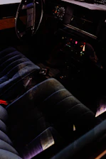 A cozy car interior featuring a sleek dashboard with a newly installed car radio glowing softly in deep crimson and forest green accents.