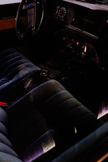 A cozy car interior with a sleek dashboard featuring a newly installed car radio glowing softly in deep crimson light.