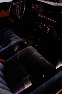 A cozy car interior with a sleek dashboard featuring a newly installed car radio glowing softly in deep crimson light.
