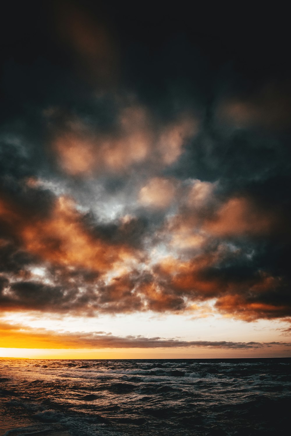 Meer unter schweren Wolken während der goldenen Stunde