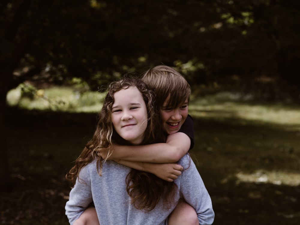 boy riding girl's back during day