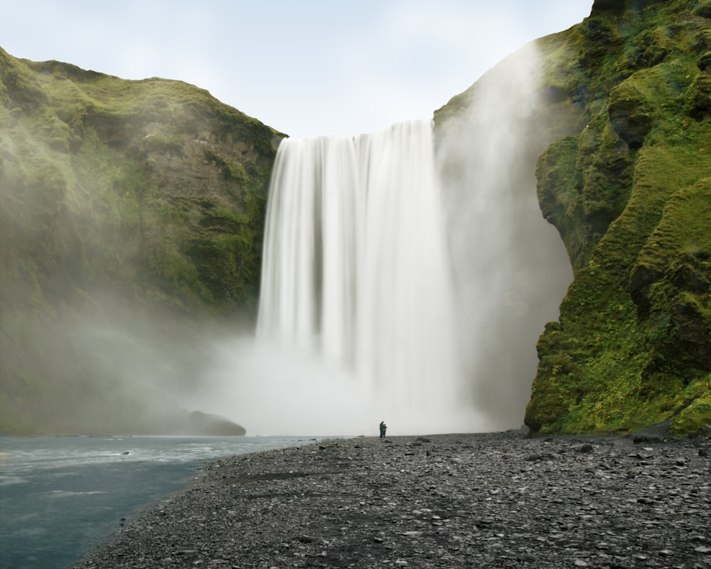 person standing near waterfalls