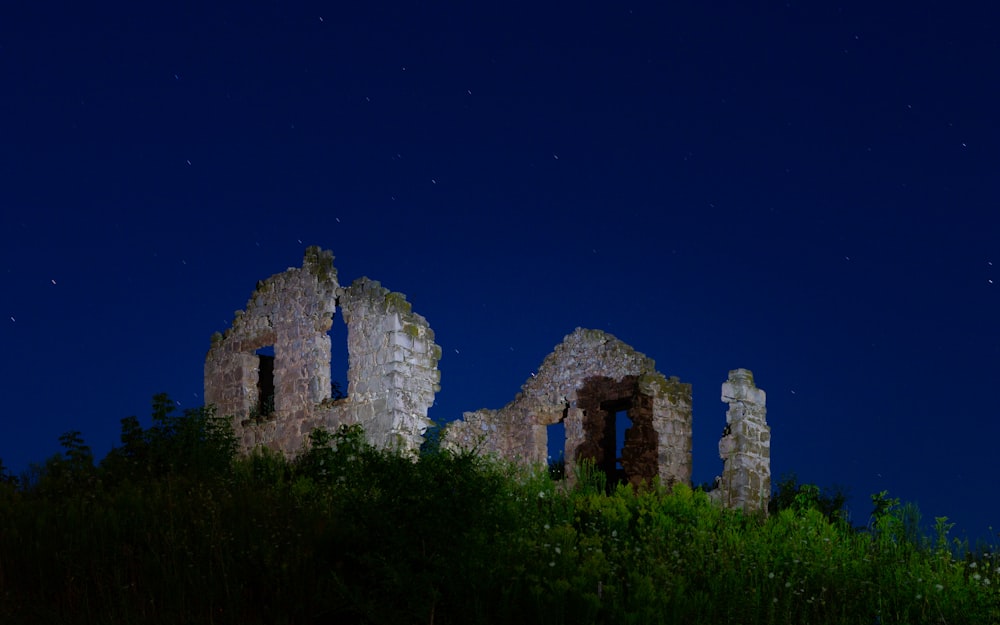 an old building sitting on top of a lush green hillside