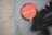 A circular sticker is attached to a weathered surface, featuring an orange design with the words 'CONFIDENCE.TRUTH' in white letters. The surface to which the sticker is adhered appears rough and textured, showing some signs of wear and rust.