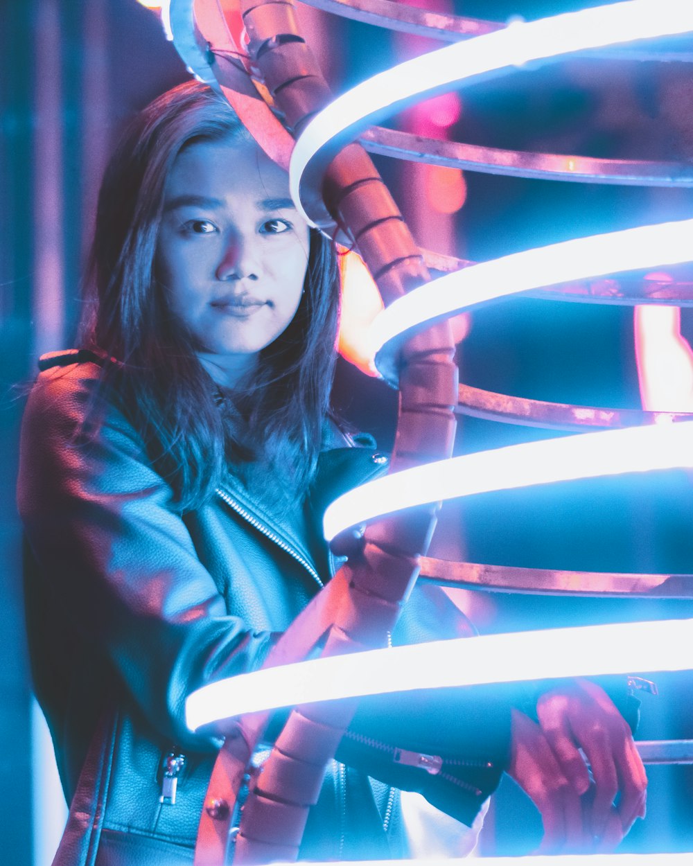 standing woman beside neon light