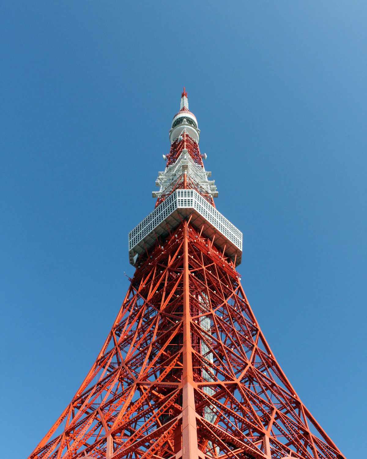 Tokyo Tower's red and white steel frame against a blue sky