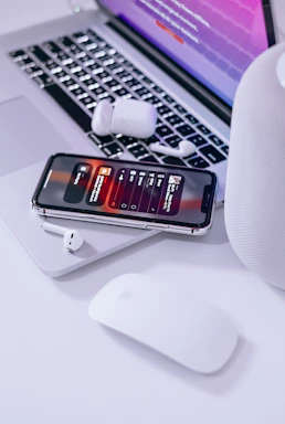 A cozy workspace with a laptop, headphones, and a sleek Bluetooth speaker glowing softly.