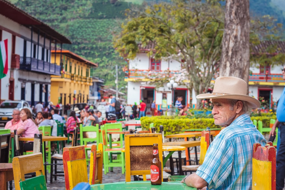 homme assis devant la table de patio vert