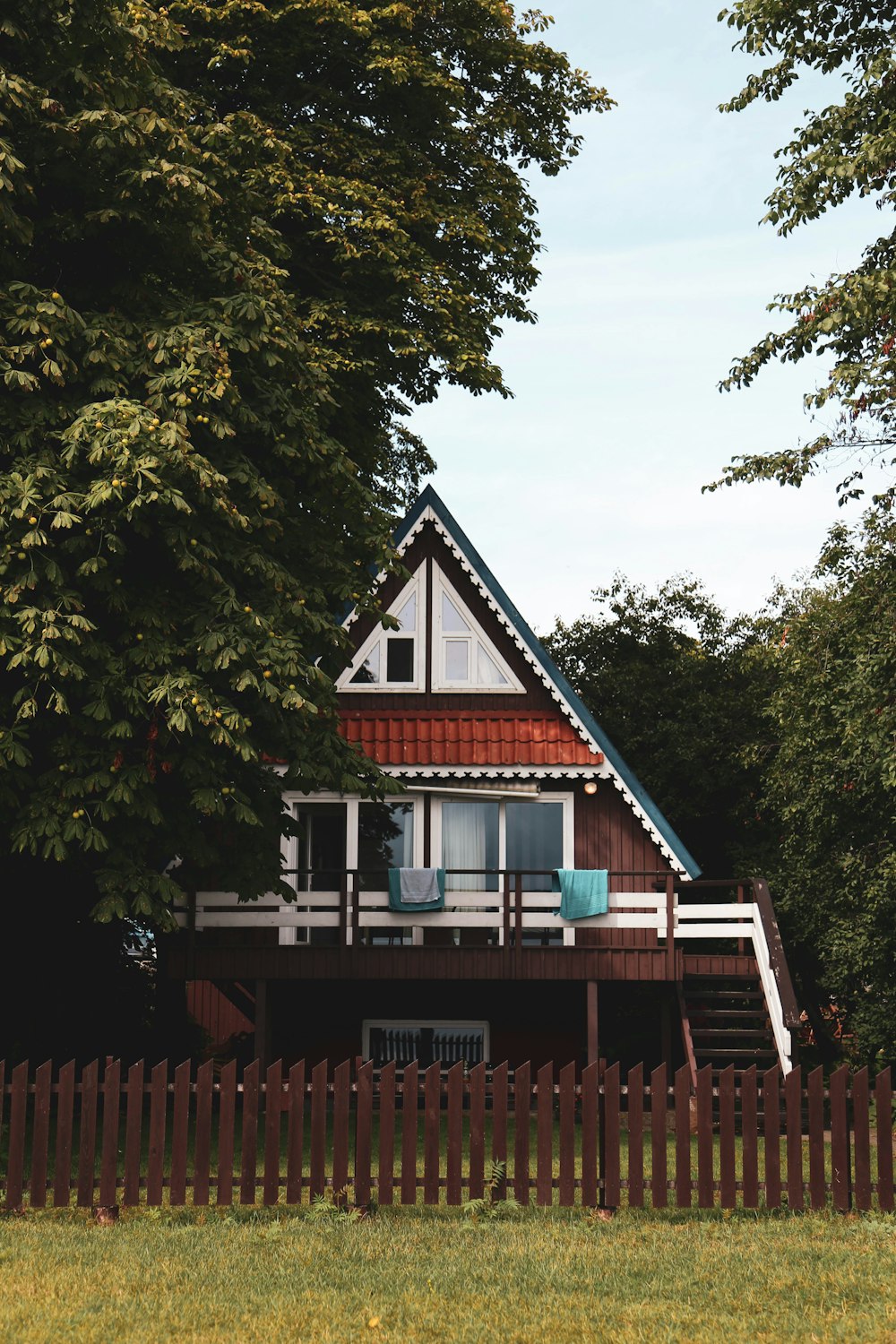 brown wooden house with wooden fence near tree