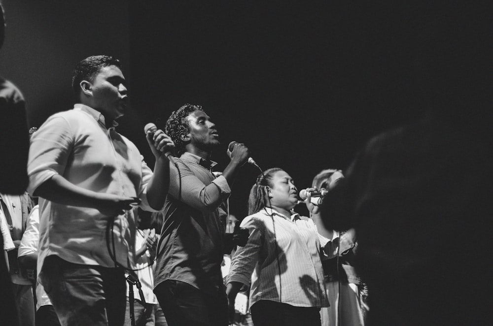 a black and white photo of a group of people singing