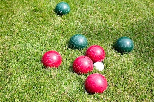 red and green Bocce Ball balls in green field