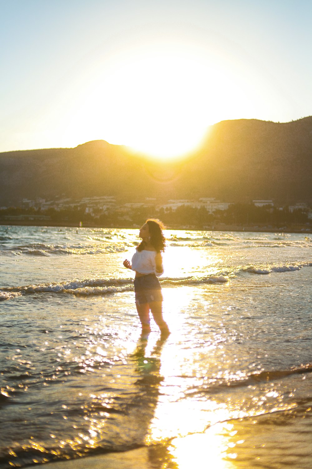 woman standing near seashore during sunset