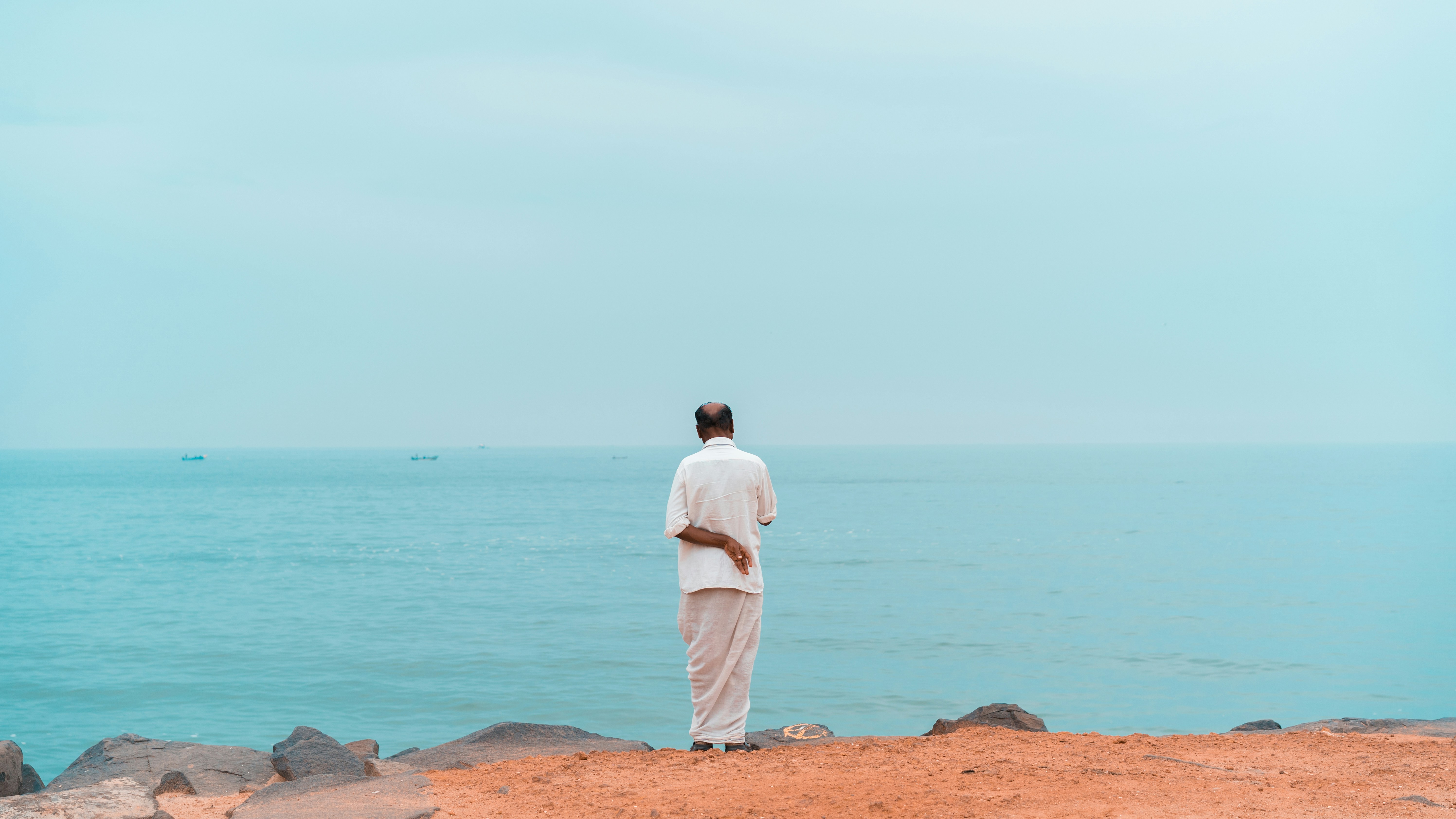 man standing behind body of water