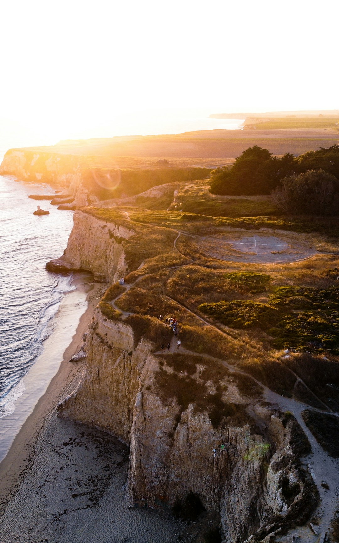 landscape photo of gray and green cliff beside body of water