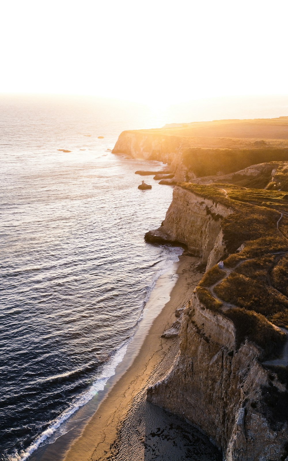 landscape photography of green and brown cliff beside shoreline