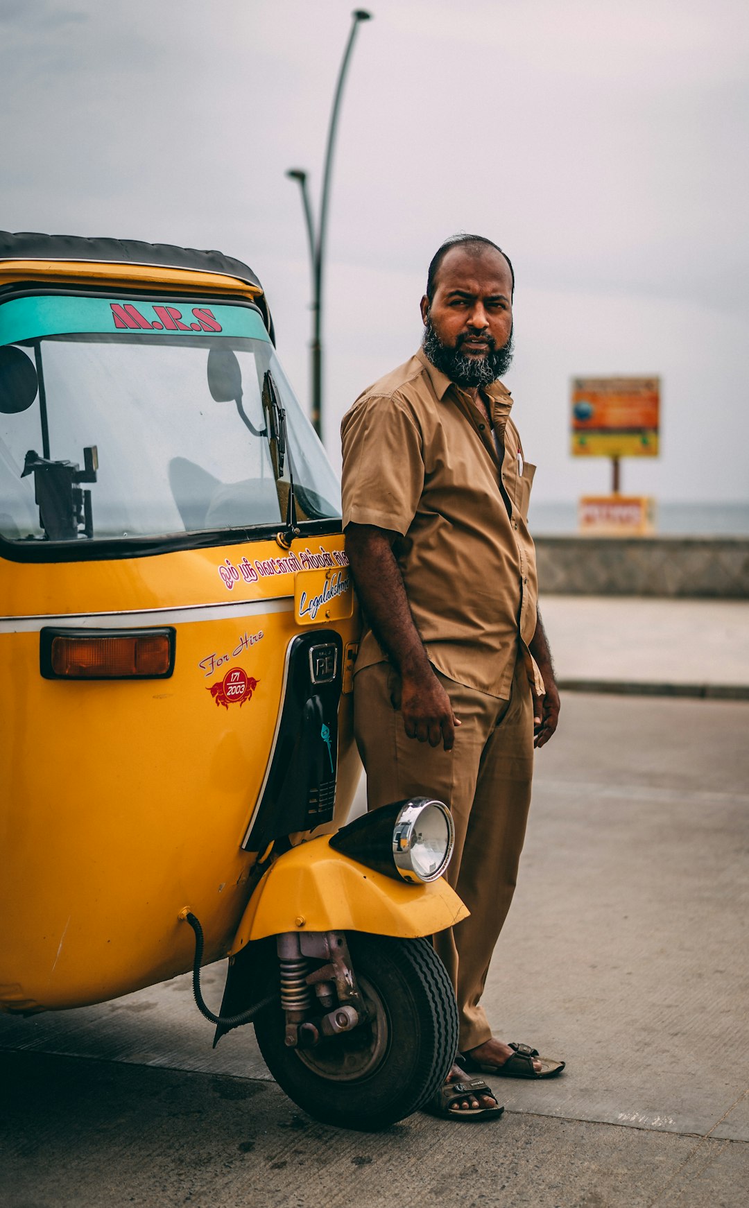 man standing beside auto-rickshaw