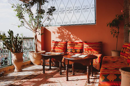 An inviting outdoor patio setup with stylish cushions and decorative plants.