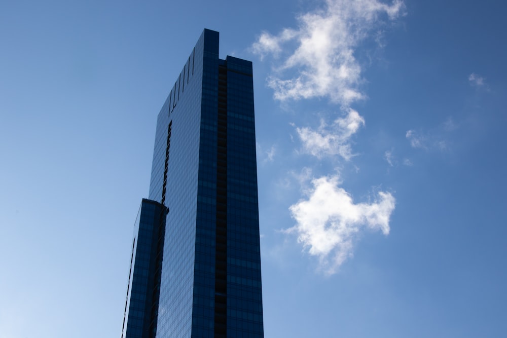 푸른 색과 흰 하늘 아래 푸른 유리 벽으로 둘러싸인 고층 건물