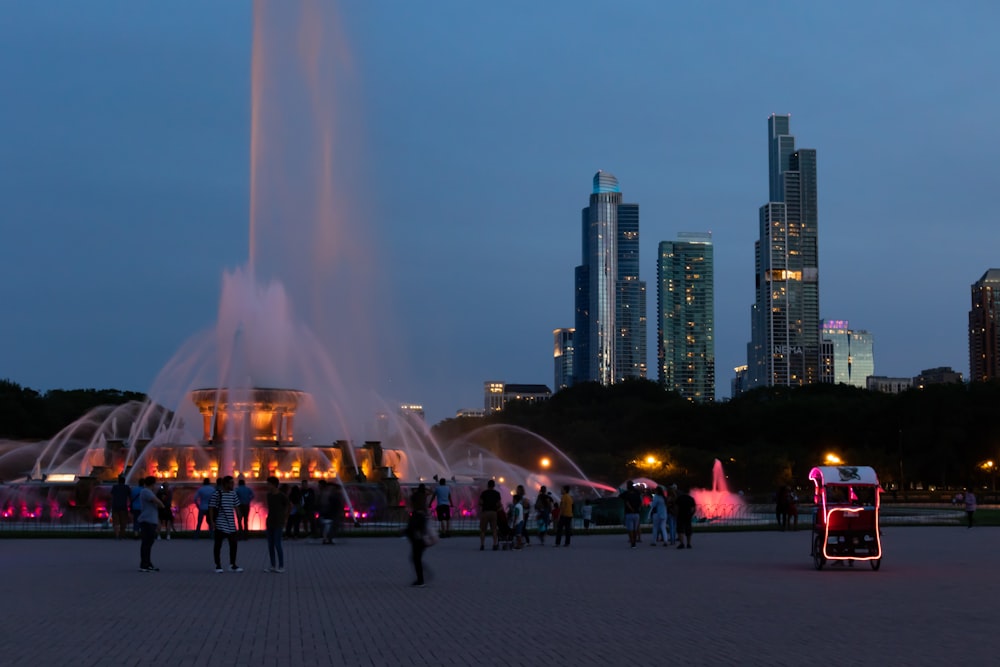 a group of people standing in front of a fountain