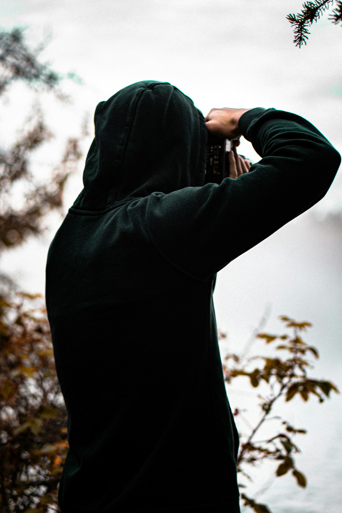 Black zip hoodie worn from the back in the same neutral studio