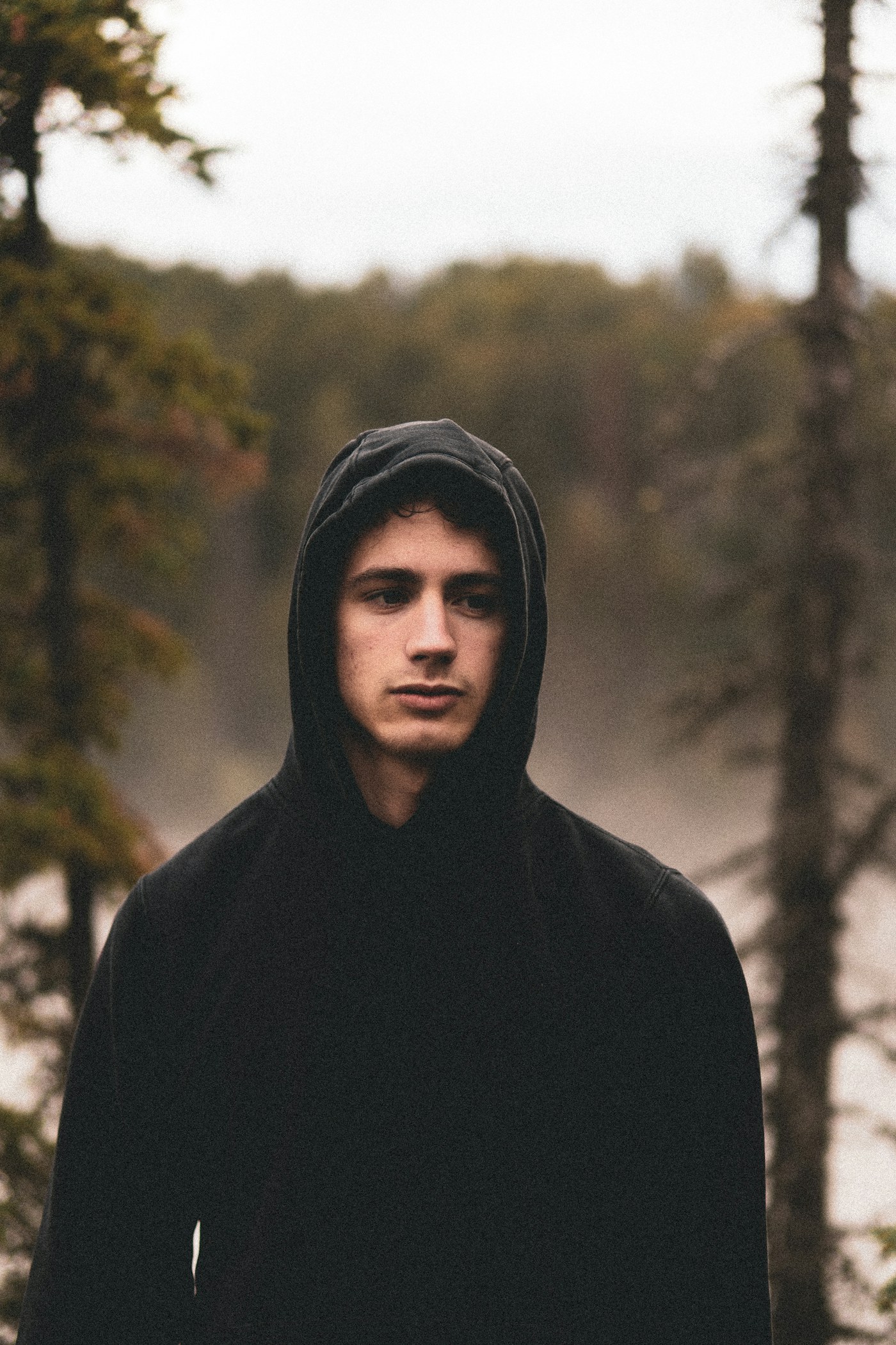 Black zip hoodie worn from the front in a neutral studio