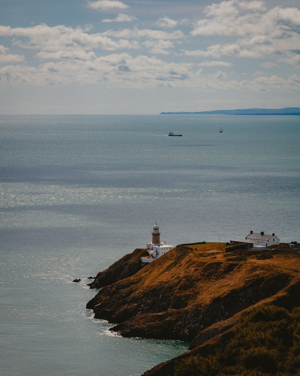 lighthouse near body of water during daytime