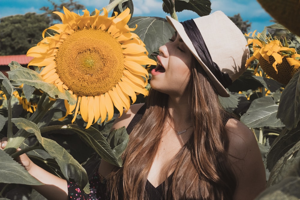 woman standing near blooming yellow sunflower