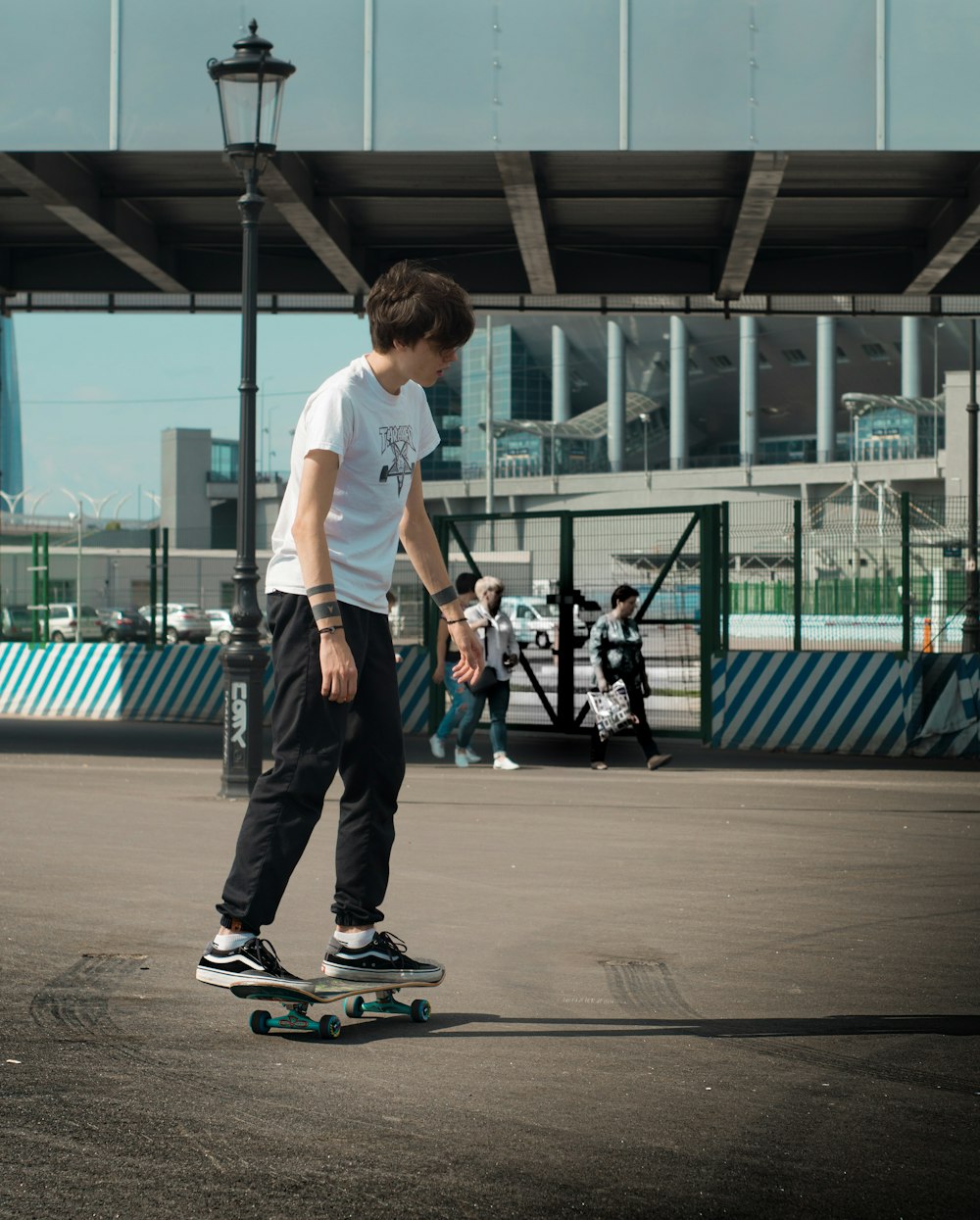 Mann fährt auf schwarzem Skateboard neben grauem Gebäude