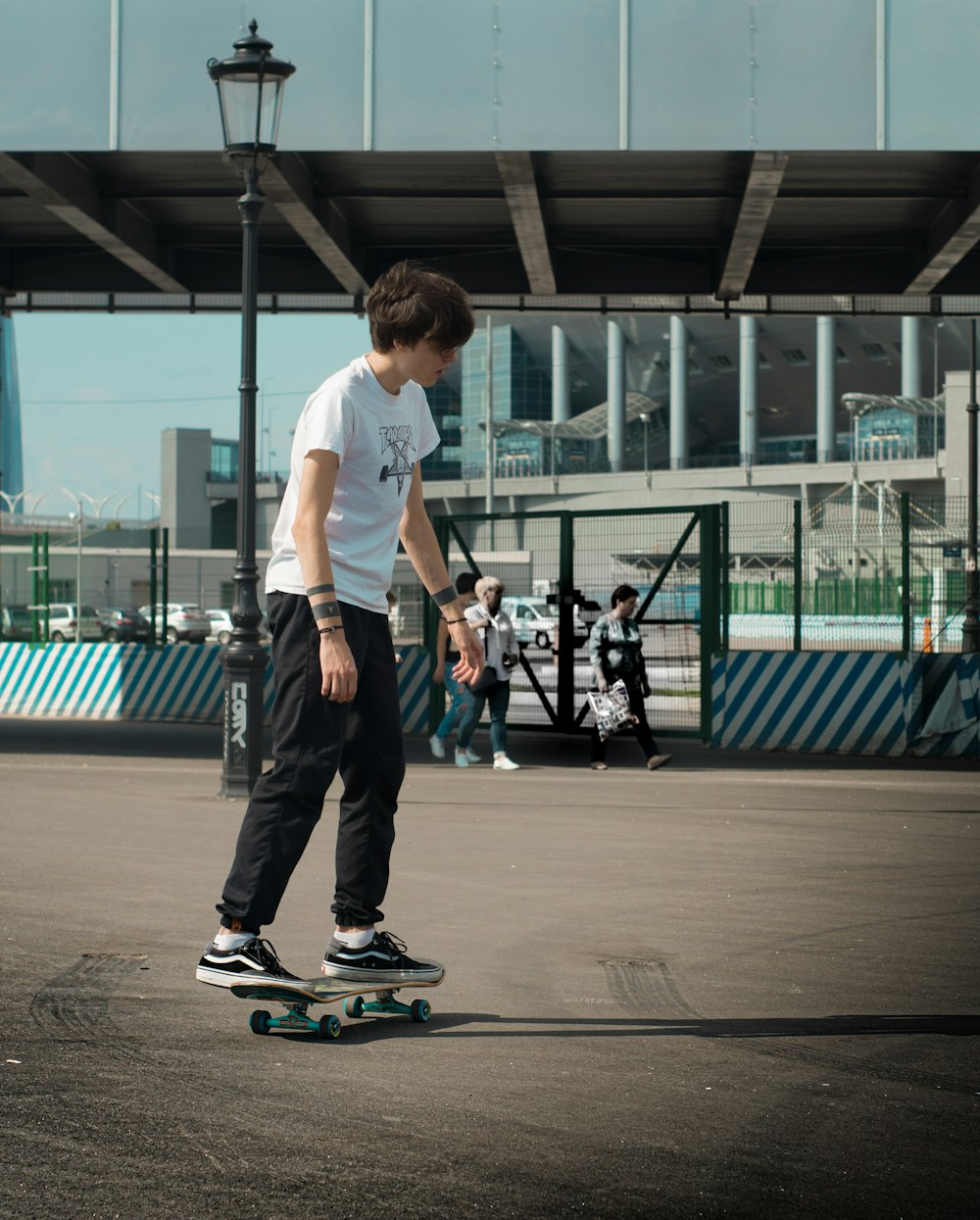 man riding on black skateboard beside gray building