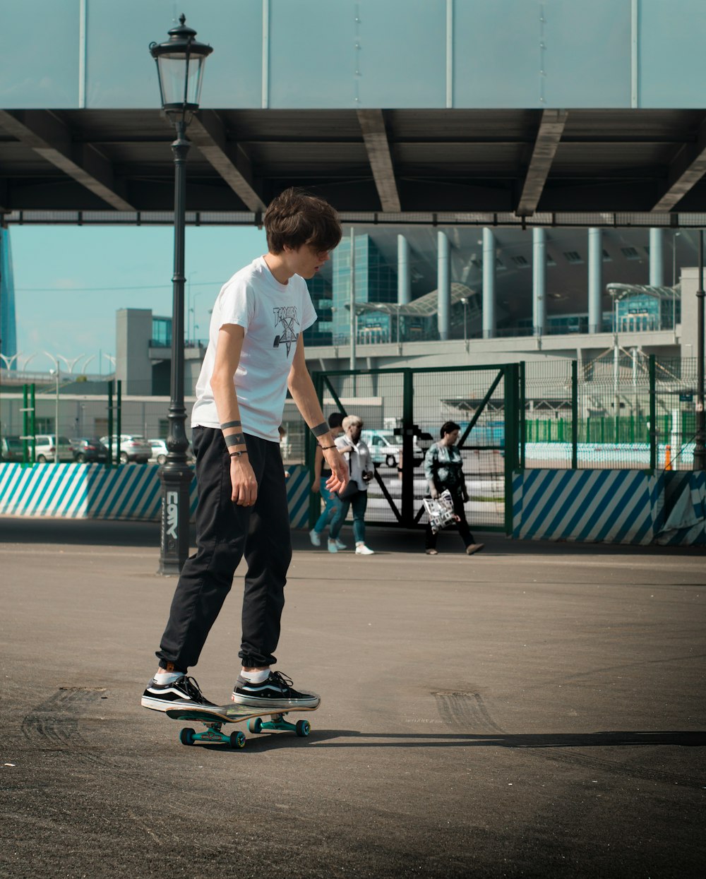 man riding on black skateboard beside gray building