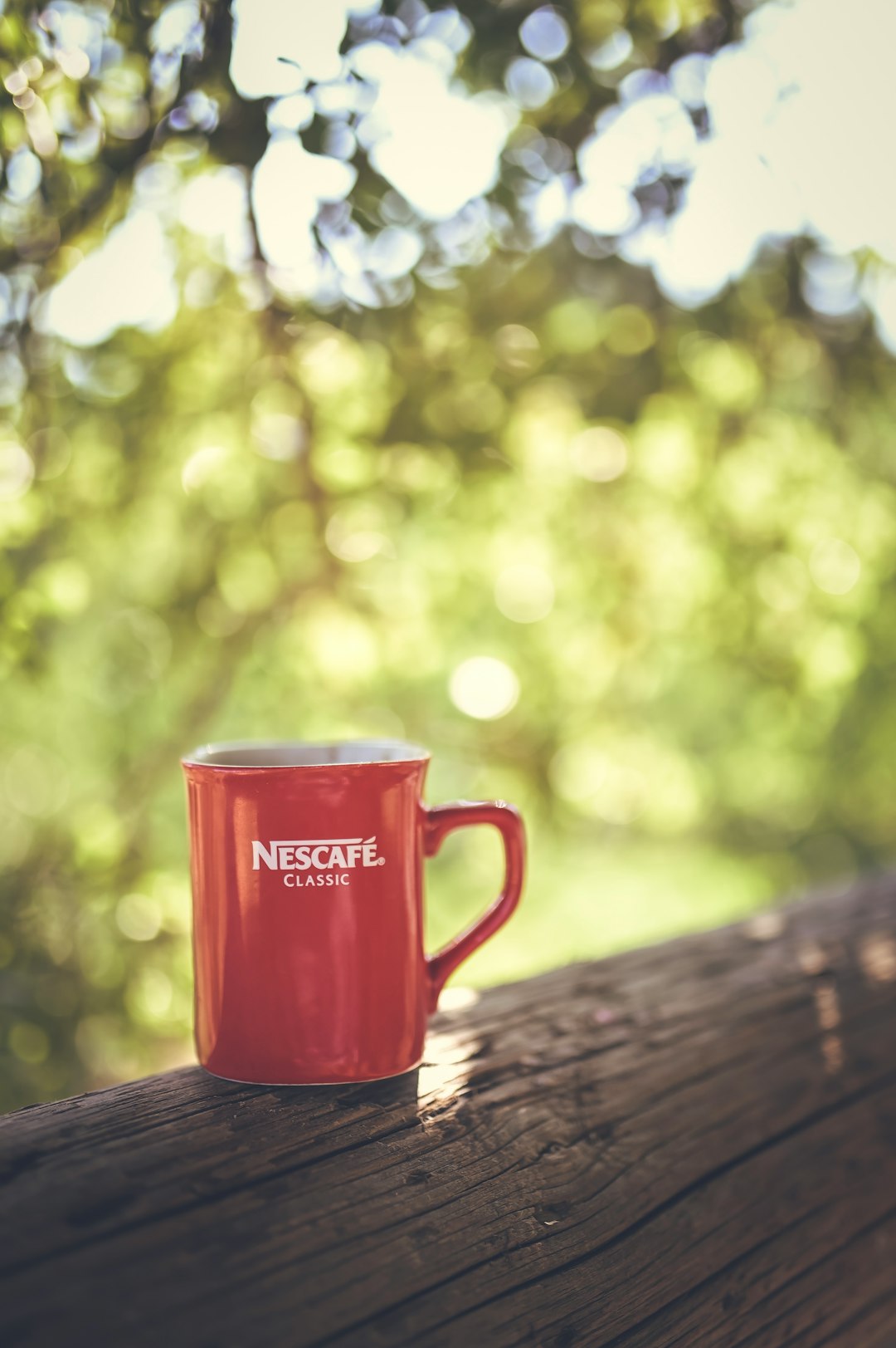 red Nescafe mug on beige surface