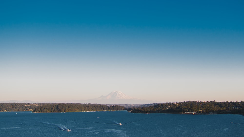 a large body of water with a mountain in the background