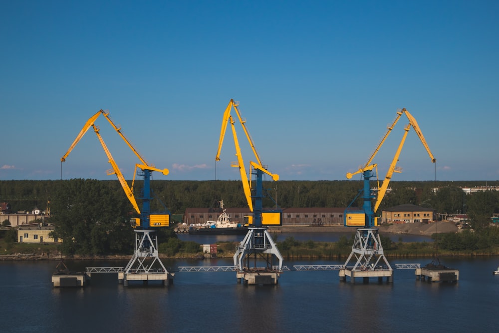 three lined cranes near trees