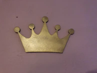 A golden crown resting on a purple velvet cushion, representing the party’s royal inspiration.