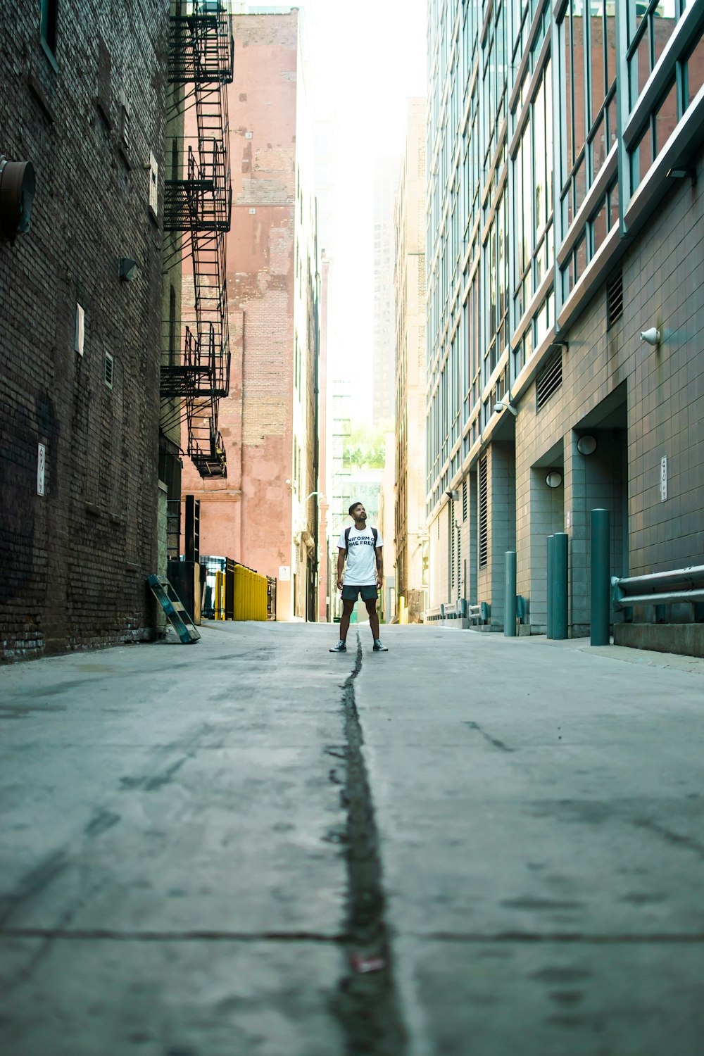 man standing in middle of road during daytime