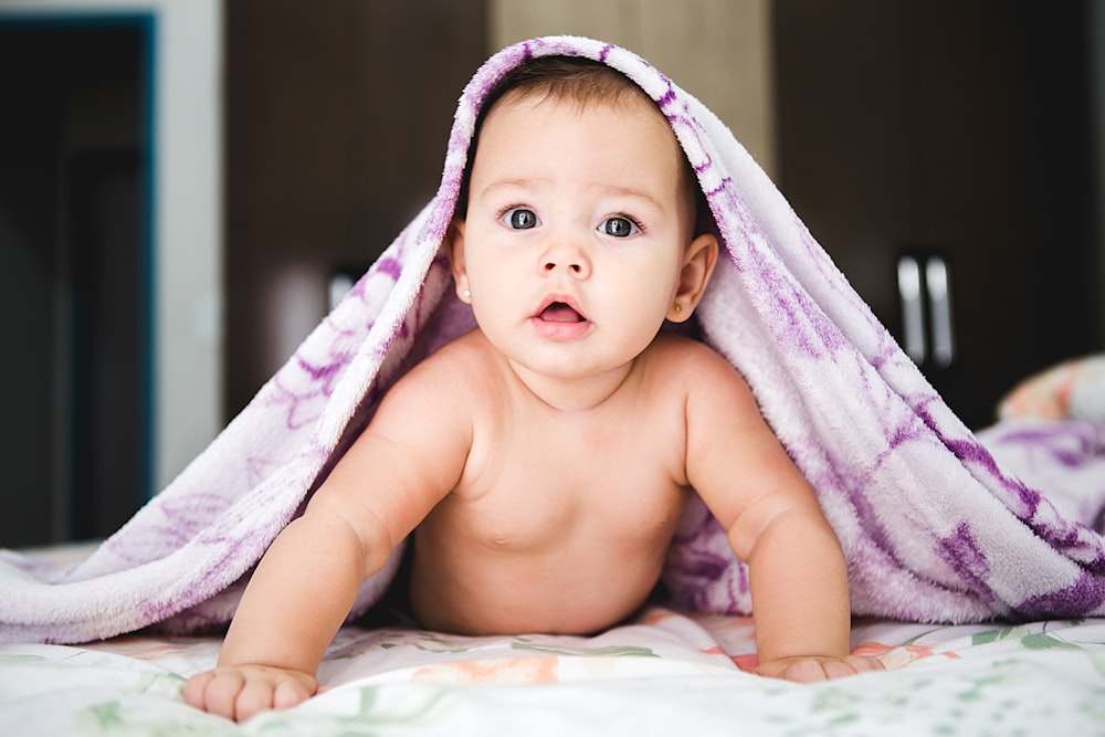 bebé bajo manta morada