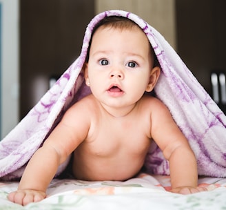 baby under purple blanket