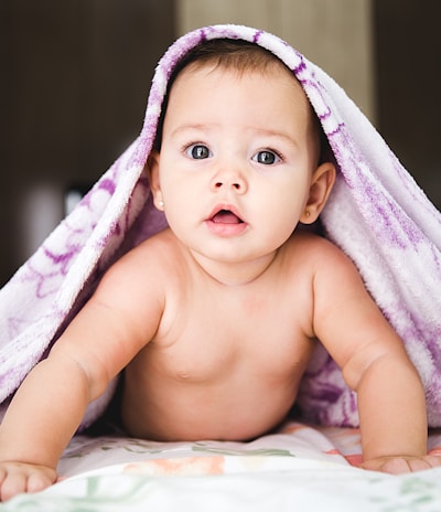 baby under purple blanket