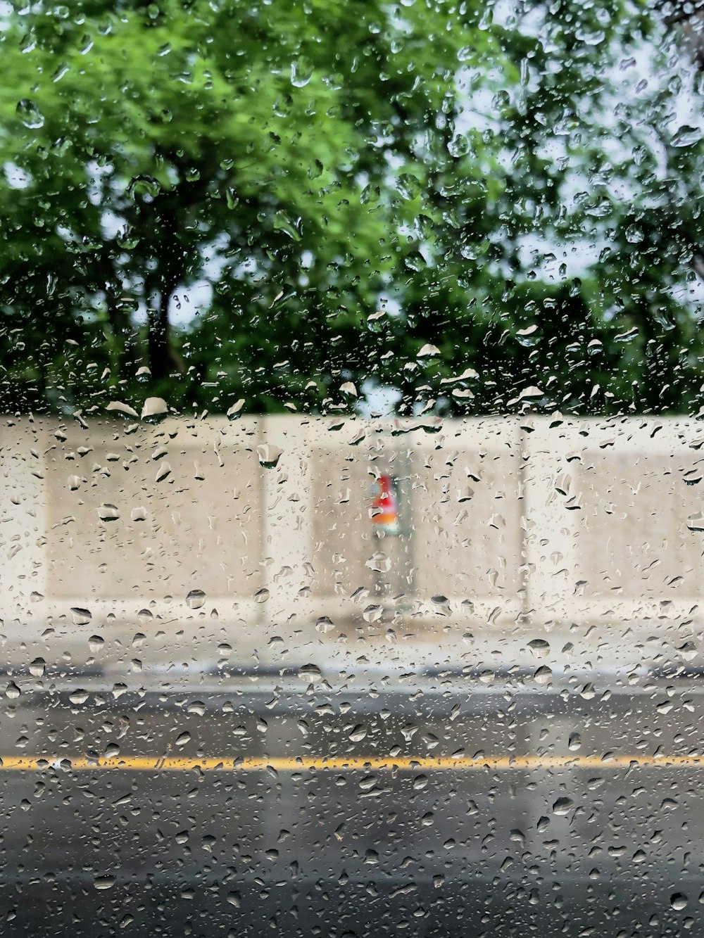 Rain drops on a window with a traffic cone in the background photo ...