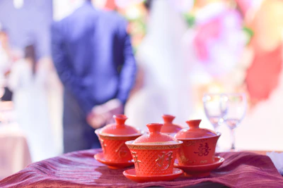 Set of four ceremonial cups arranged on a white cloth with subtle red accents.