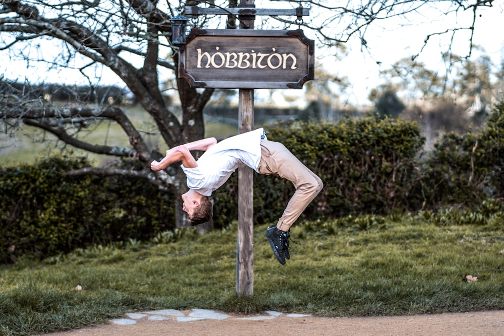 man backflips at Hobbiton signage