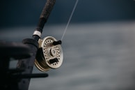 Close-up of a custom fishing rod handle with intricate wood grain and Badger Built Fishing logo.