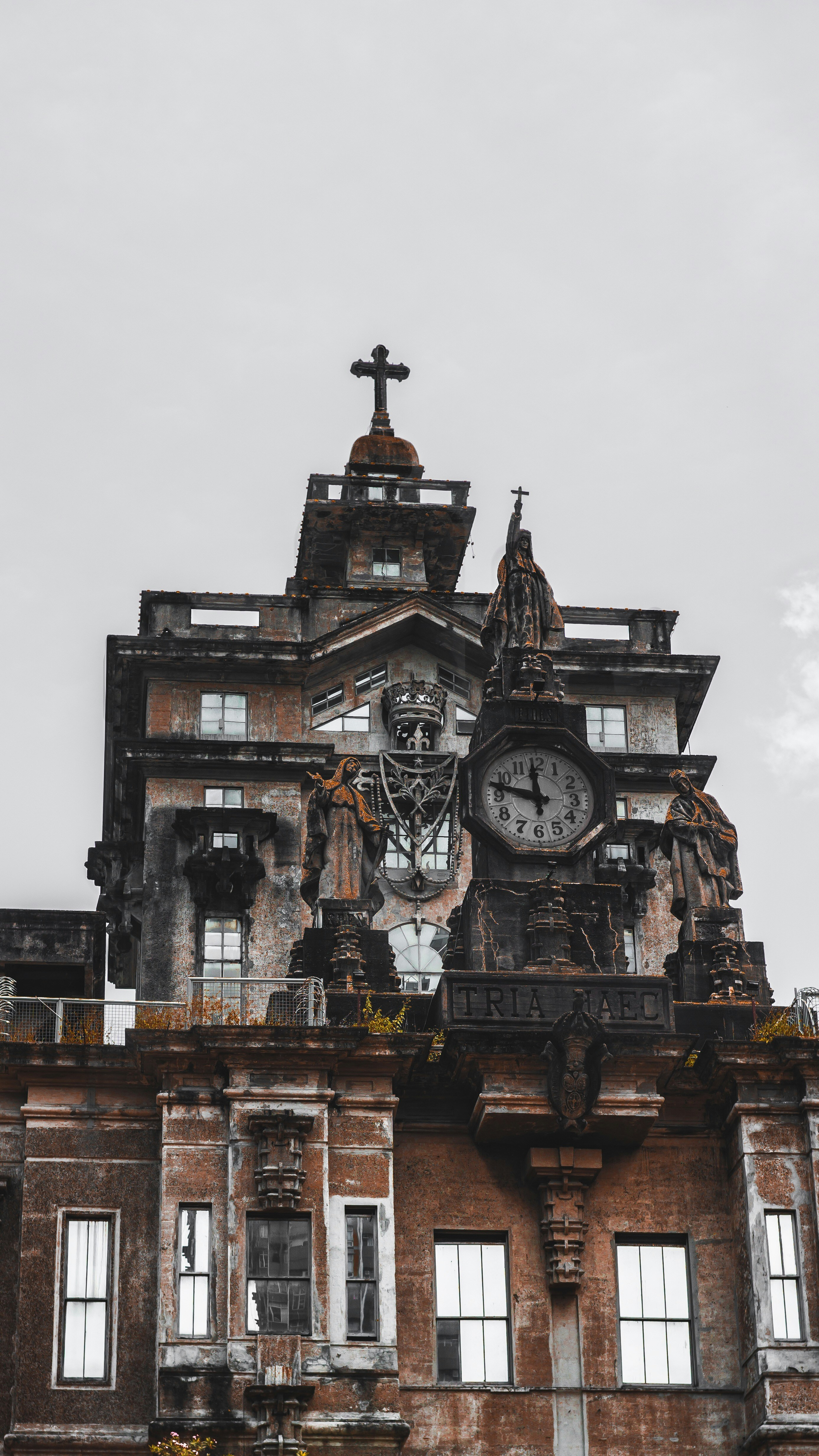 edifício marrom com relógio sob o céu cinzento