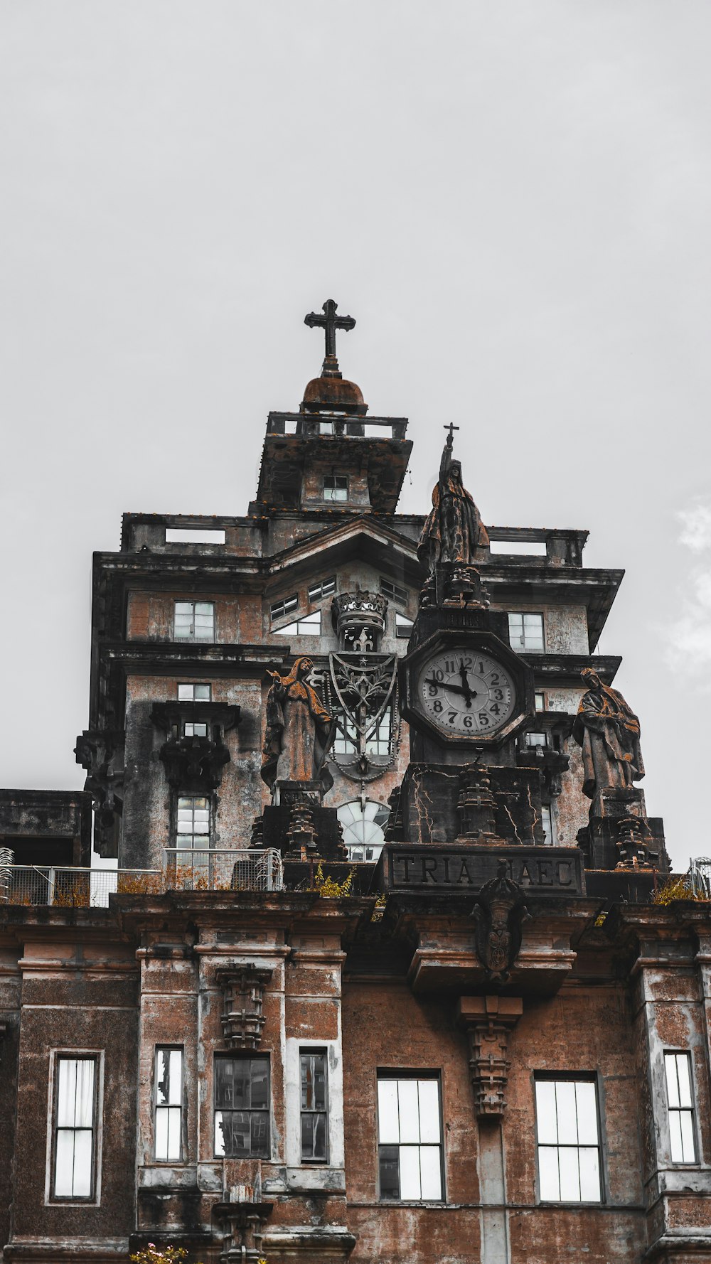 Edificio marrón con reloj bajo cielo gris