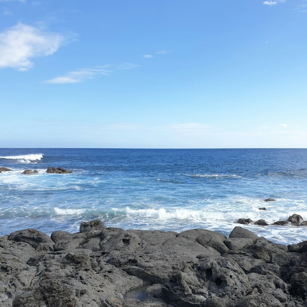 a view of the ocean from a rocky shore